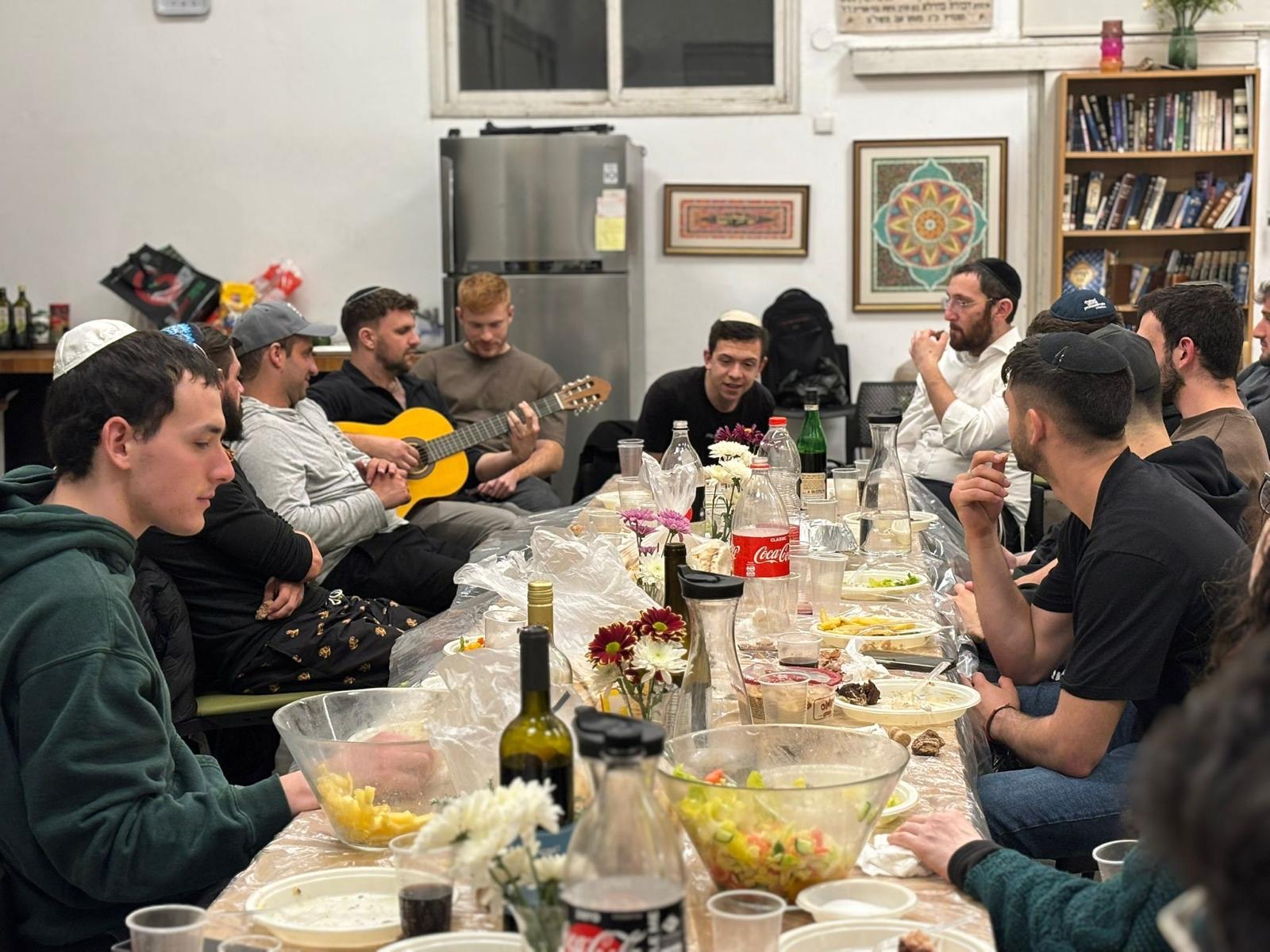 Cena de Shabat con guitarra alrededor de una mesa larga en La Casa